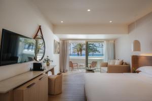 a hotel room with a bed and a living room at Nissi Beach Resort in Ayia Napa