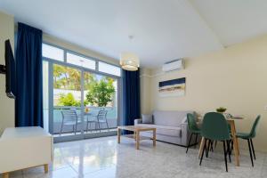 a living room with a couch and a table and chairs at Fayna Apartments in Playa del Ingles