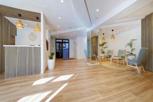 a living room with a wooden floor and chairs at Fayna Apartments in Playa del Ingles +64 photos