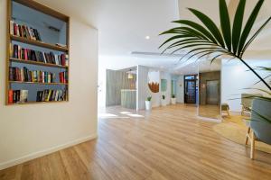 a living room with a book shelf and a plant at Fayna Apartments in Playa del Ingles