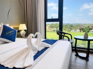a hotel room with two swans towels on a bed at Athena Coto Hotel in Nam Cap