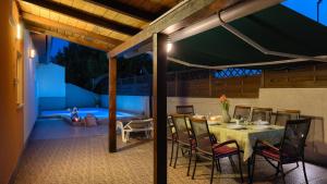 a dining room with a table and chairs on a patio at Casa Aneri by Villas Guide in Pavicini