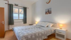 a bedroom with a bed with two lamps and a window at Casa Aneri by Villas Guide in Pavicini +41 photos