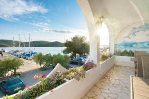 a balcony with flowers and a view of a marina at Irene Bed & Breakfast Tisno in Tisno