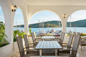 a patio with tables and chairs and a view of a harbor at Irene Bed & Breakfast Tisno in Tisno +68 photos