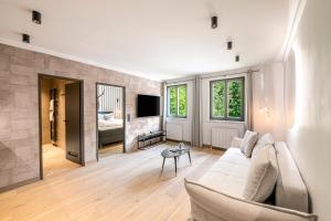 a living room with a white couch and a tv at Residenz Boutique Suites in Bad Gastein