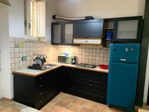 a kitchen with a blue refrigerator and a sink at Casa Mao in Noto