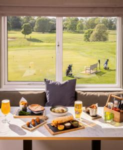 a table with food and a view of a golf course at Roxburghe Cottages, part of Destination by Hyatt in Kelso