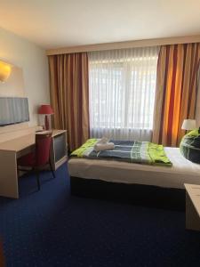 a hotel room with a bed and a desk and a desk at Hotel Regina Suites in Sankt Augustin +36 photos