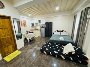 a bedroom with a bed and a kitchen with a table at The Uptown deluXE Studio #5 in Balulang