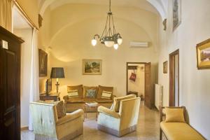 a living room with a couch and chairs and a chandelier at Casa Becci Central Large & Sunlit Historical Flat in San Gimignano