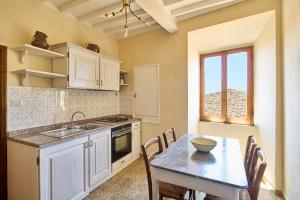 a kitchen with a table and a dining room at Casa Becci Central Large & Sunlit Historical Flat in San Gimignano