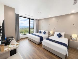 a hotel room with two beds and a large window at Athena Coto Hotel in Nam Cap
