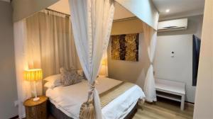 a bedroom with a bed with a canopy at Constantia Hotel and Conference Centre in Midrand