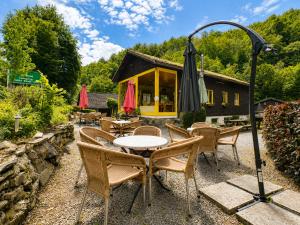 a patio with tables and chairs and an umbrella at Camping La Lienne in Stoumont
