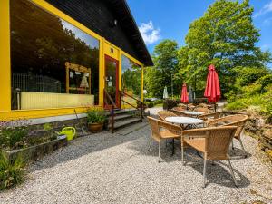 a patio with chairs and a table and umbrellas at Camping La Lienne in Stoumont