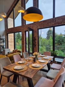 a dining room with a wooden table and chairs at Trei Mândre by Cabana CeiTrei in Cozăneşti