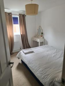 a bedroom with a bed and a mirror and a window at FV Dwelling in Nottingham