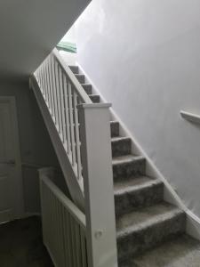 a staircase in a house with a white stair case at FV Dwelling in Nottingham