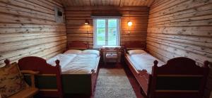 a room with two beds in a log cabin at Skotten Seter - Bed & Husky in Mork