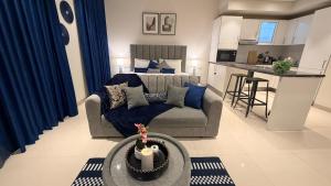 a living room with a couch and a kitchen at Navy Studio By Bait Zain in As Sīfah