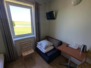 a room with a couch and a table and a window at Trevena Endriejavas in Endriejavas