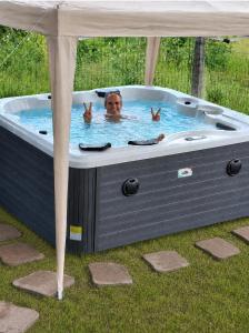 a woman is in a jacuzzi in the grass at Antico Chalet Momosa Maxi in Ovindoli