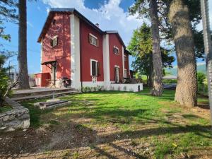 a red and white house with trees in the yard at Antico Chalet Momosa Maxi in Ovindoli