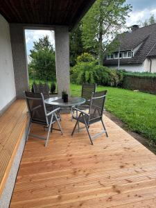 a patio with a table and chairs on a deck at bei gitta in Olpe
