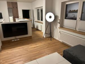 a living room with a flat screen tv and a fan at bei gitta in Olpe