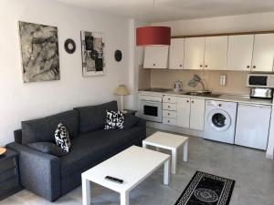 a living room with a couch and a kitchen at Veracoast 133 in Los Amarguillos
