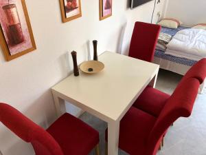 a room with a table with red chairs and a bed at Veracoast 133 in Los Amarguillos +7 photos