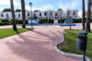 a park with a trash can in front of a building at Veracoast 133 in Los Amarguillos
