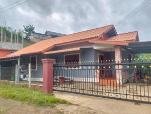 a house with a fence in front of it at Ban Thong hostel in Luang Prabang