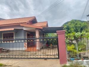 a house with a fence in front of it at Ban Thong hostel in Luang Prabang