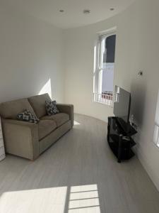 a living room with a couch and a television at 1 bedroom flat in Saint Helier Jersey
