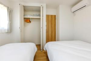 a bedroom with two beds and a closet at Asobi Stay大日 山吹 in Nagoya