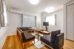 a living room with a couch and a table and chairs at Asobi Stay大日 山吹 in Nagoya