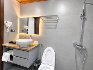 a bathroom with a sink and a toilet and a shower at Athena Coto Hotel in Nam Cap