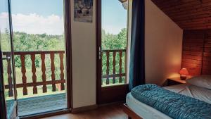 a bedroom with a balcony with a bed and a window at Gite De La Mortagne in Mortagne