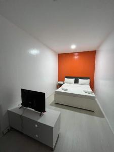 a bedroom with a bed and a flat screen tv at The Beach House and Bar in Roxas City