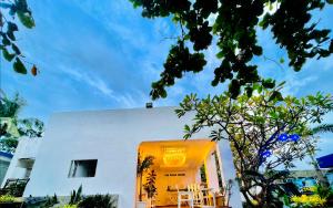 a white house with an orange door and a tree at The Beach House and Bar in Roxas City
