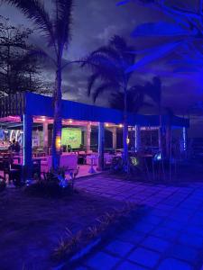 a resort with palm trees and lights at night at The Beach House and Bar in Roxas City