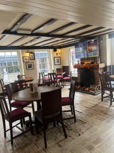 a dining room with tables and chairs and a fireplace at Ye Olde Talbot Hotel by Greene King Inns in Worcester