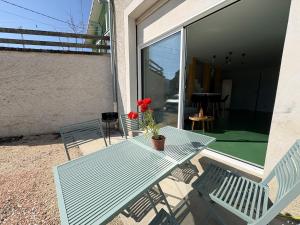 a blue picnic table with a vase with a flower on it at L'échappée verte in Chirens