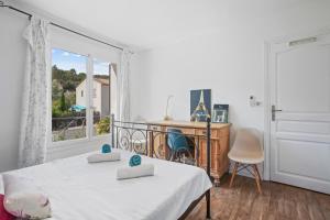 a bedroom with a bed and a desk and a window at Villa Etoile in Cabasse
