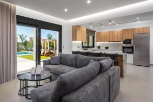 a living room with a couch and a kitchen at Villa Elesia in Kremasti
