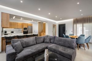 a living room with a gray couch and a kitchen at Villa Elesia in Kremasti +29 photos