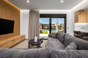 a living room with a couch and a television at Villa Elesia in Kremasti