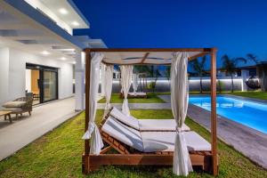 an outdoor bedroom with a canopy bed and a swimming pool at Villa Elesia in Kremasti